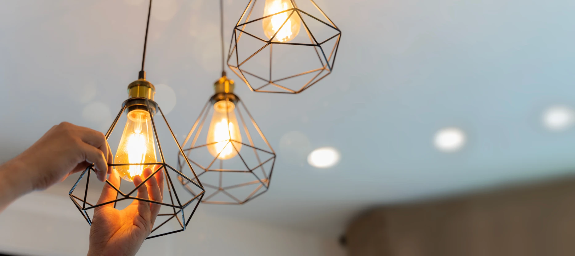 Un électricien installe des projecteurs au plafond
