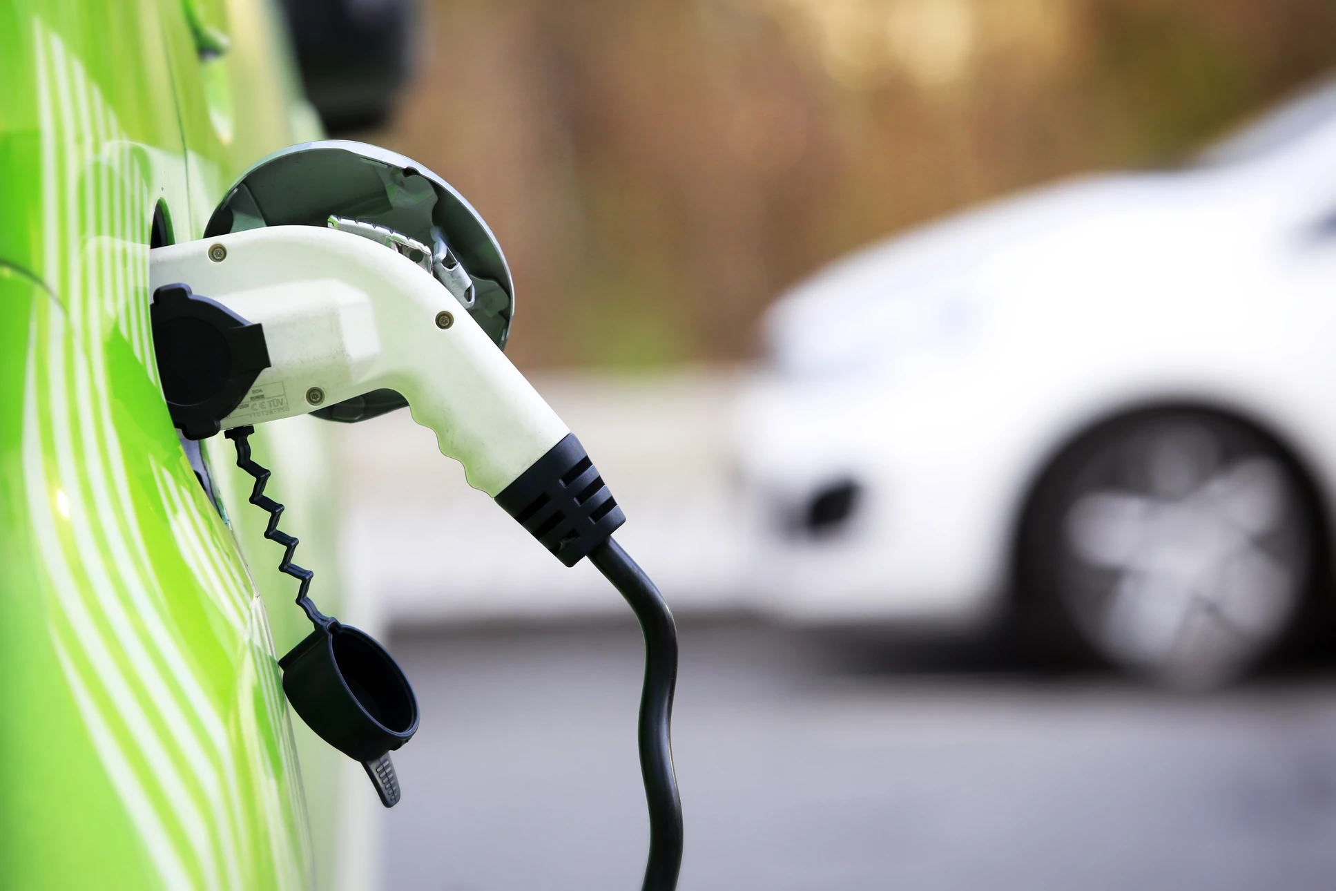 Scène extérieure urbaine avec véhicule électrique blanc en cours de recharge