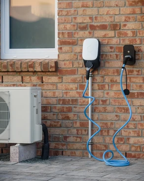 Scène extérieure ensoleillée avec véhicule électrique en cours de recharge